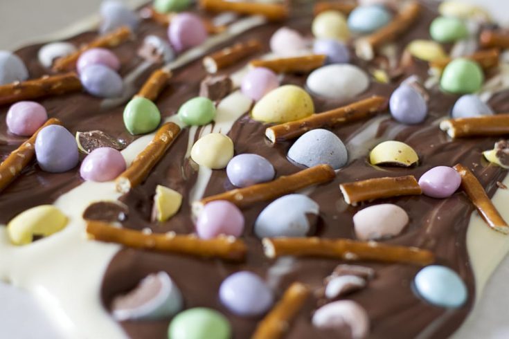 Up close view of chocolate bark topped with pretzels and Easter candy