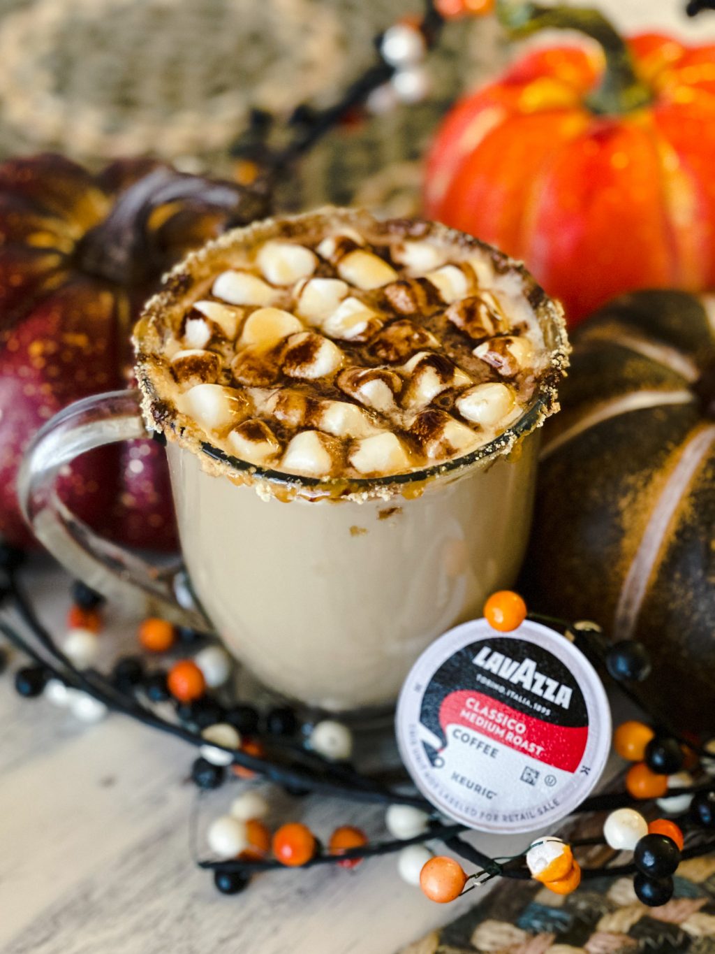 smores latte in clear mug with multi-colored pumpkins