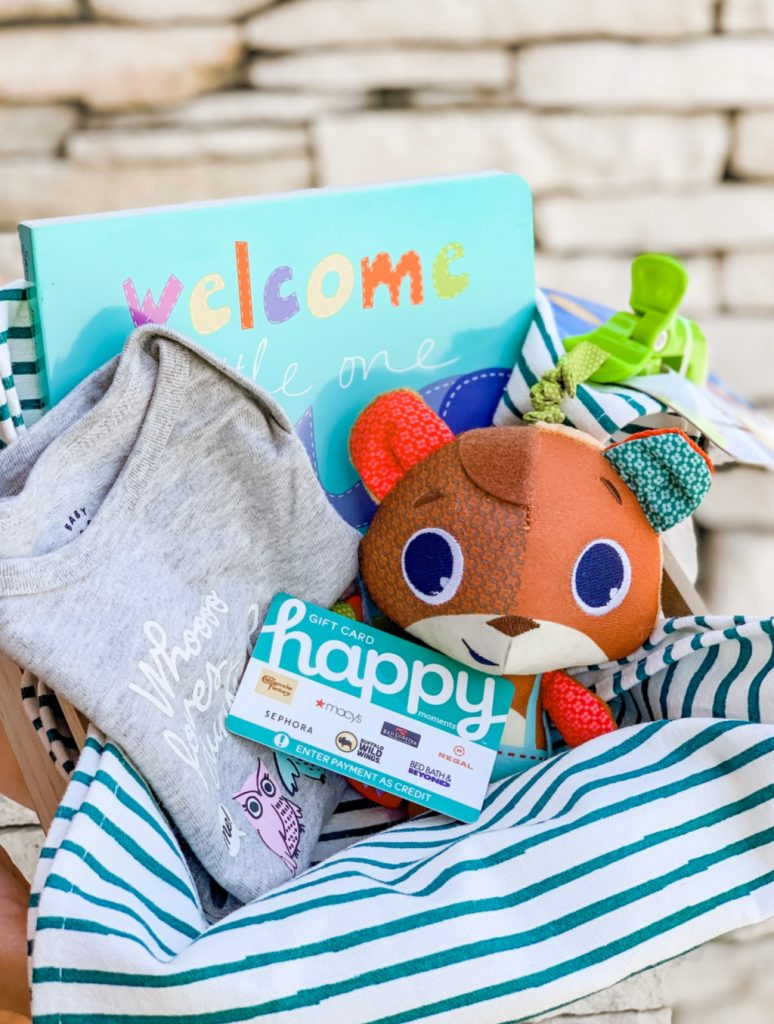 baby gift basket filled with gray baby onesie, baby board book and squirrel toy