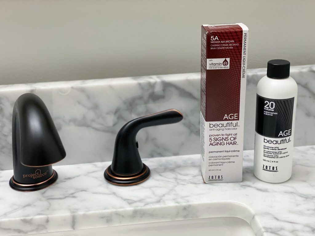 agebeautiful hair color bottles on white marble bathroom counter