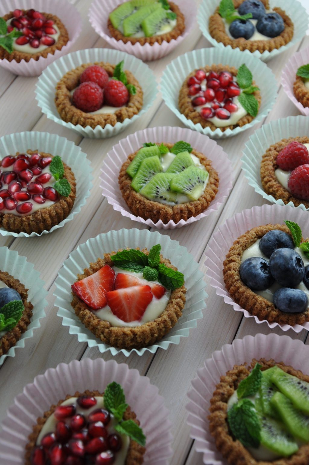 fruit tarts in cupcake liners on top of white wooden table from an eating plan recipe book